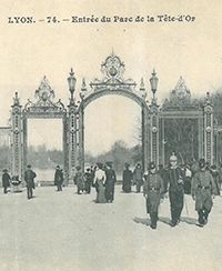 Photo ancienne de la porte principale du parc de la tte dor devant laquelle dambule des gens en tenue dpoque