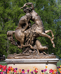Photo d’une statue du parc de la Tête d’or représentant une femme avec un corps de cheval, un homme et un félin. Photo d’une statue du parc de la Tête d’or représentant une femme avec un corps de cheval, un homme et un félin.