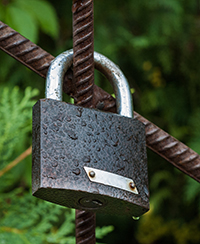 Photo d’un cadenas qui verrouille des barres de métal Photo d’un cadenas qui verrouille des barres de métal